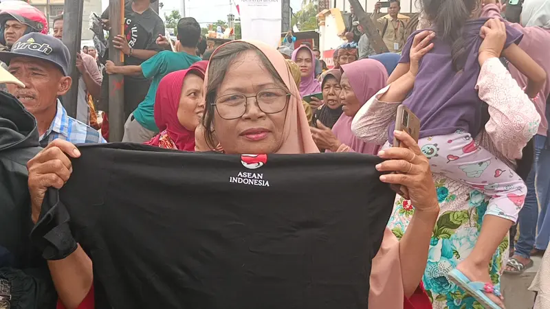 Pastin (55), warga asal Desa Dologan, Kecamatan Japah, Kabupaten Blora, Jawa Tengah, memperlihatkan kaus dari Presiden Jokowi. (Liputan6.com/Ahmad Adirin)