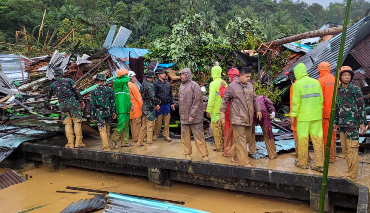 Tim penyelamat sedang memeriksa kerusakan akibat tanah longsor di Natuna, Kepulauan Riau (Kepri) dalam foto selebaran yang diambil dan dirilis pada 7 Maret 2023 oleh kantor Kementerian Komunikasi dan Informatika Natuna. Pemkab Natuna pada Selasa menetapkan status tanggap darurat bencana longsor selama 7 hari, mulai 6-12 Maret 2023. (HO / Natuna ministry of communication / AFP)