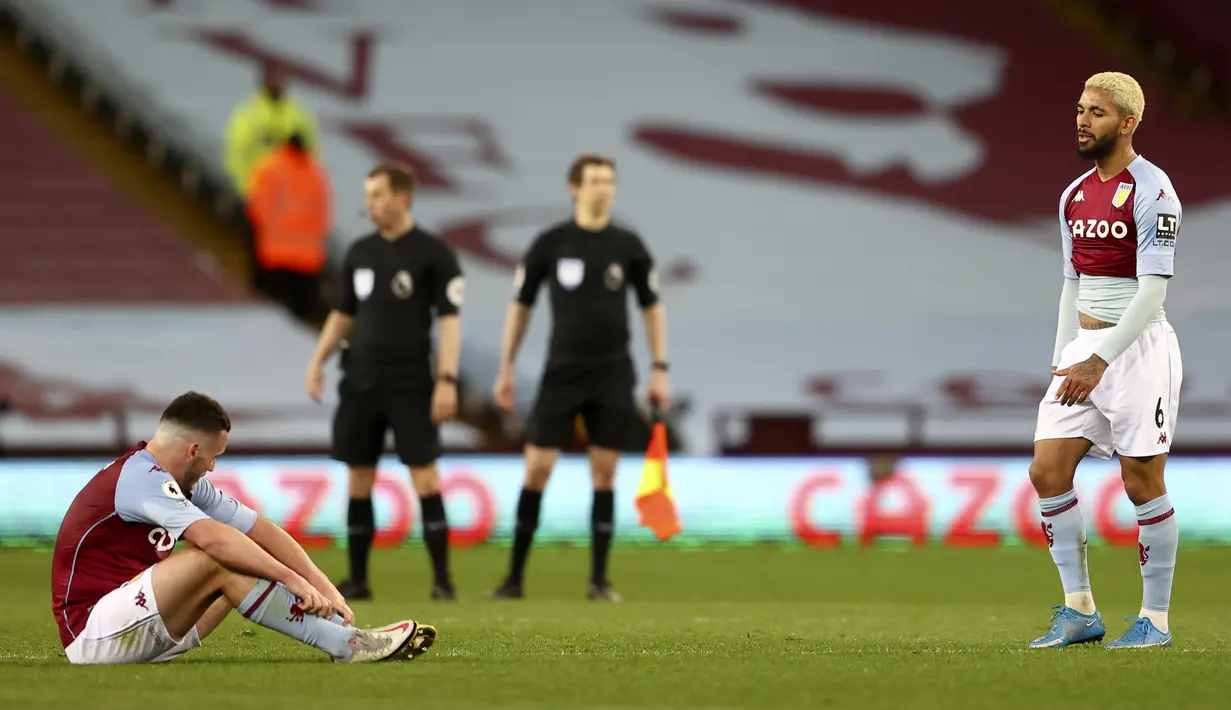 Reaksi pemain Aston Villa John McGinn (kiri) dan Douglas Luiz saat akhir laga melawan Manchester City pada pertandingan Liga Inggris di Villa Park Stadium, Birmingham, Inggris, Rabu (21/4/2021). Manchester City menang 2-1. (Michael Steele/Pool via AP)