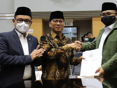 Menteri Agama Yaqut Cholil Qoumas (kanan) menerima dokumen Penetapan Biaya Penyelenggaraan Ibadah Haji Tahun 1443 H/2022 dari Ketua Komisi VIII DPR Yandri Susanto dalam rapat kerja dengan Komisi VIII DPR di Kompleks Parlemen, Senayan, Jakarta, Rabu (13/4/2022). (Liputan6.com/Angga Yuniar)