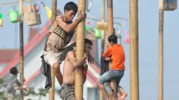 Sejumlah warga berebut memanjat pada lomba Panjat Pinang Kolosal dalam rangka merayakan HUT RI ke-70 di Pantai Karnaval, Ancol, Jakarta, Senin (17/8). Sebanyak 124 batang pinang disediakan dengan berbagai ragam hadiah. (Liputan6.com/Herman Zakharia)