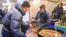 Para penjual menyiapkan makanan saat Riga Street Food Festival di Riga, Latvia, Sabtu (18/1/2020). Api unggun dan kios-kios makanan didirikan di sudut Jalan Kalku dan Valnu di Kota Tua Riga agar orang-orang dapat menikmati berbagai hidangan populer dari kota tersebut. (Xinhua/Janis)