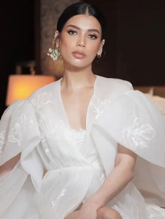 Bridal robe pilihan Sabrina Chairunnisa dengan lengan menyerupai kelopak bunga dan motif floral pada materialnya. [@archangelachelsea]