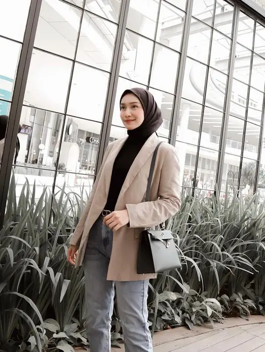 Ciptakan look kasual yang kece dengan padu padan inner dan hijab segi empat hitam, blazer krem, plus celana jeans seperti potret Melody Prima ini. (Instagram/melodyprima).