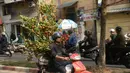 Seorang petani mengangkut pohon Kumquat untuk mengirimkannya ke pelanggan yang akan merayakan Tahun Baru Imlek di Hanoi, Vietnam, Rabu (25/1). Menurut kalender Lunar, Imlek tahun ini merupakan tahun ayam api. (Hoang DINH Nam/AFP)