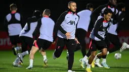 Gelandang Liverpool, Thiago Alcantara (tengah) bersama rekan setim melakukan pemanasan selama sesi latihan di AXA Training Center di Liverpool, Inggris pada 31 Oktober 2022. Liverpool akan bertanding melawan Napoli pada pertandingan lanjutan Grup A Liga Champions di Stadion Anfield, Rabu 2 November 2022, pukul 03.00 WIB. (AFP/Oli Scarff)