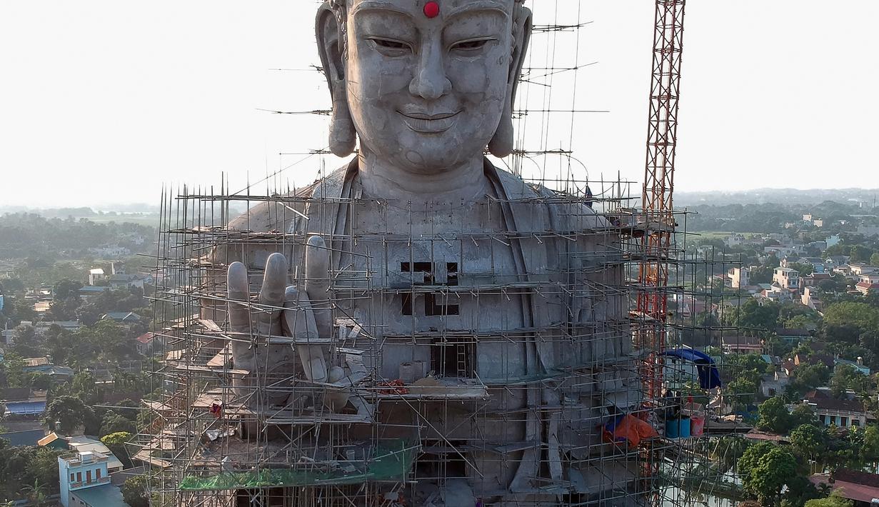 Foto udara pada 18 Mei 2019 memperlihatkan patung Buddha raksasa yang sedang dibangun di pagoda Khai Nguyen di distrik Son Tay, pinggiran Hanoi. Patung yang terletak di kawasan yang eksotis untuk dipandang mata ini nantinya akan menjadi ikon wisata religi di Vietnam. (Photo by Manan VATSYAYANA/AFP)