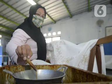 Ibu rumah tangga menyelesaikan pembuatan batik kembang mayang di Kampung Batik, Kelurahan Larangan Selatan, Kota Tangerang, Banten, Rabu (26/8/2020). Di tempat yang menjadi destinasi wisata tersebut kita bisa melihat langsung pembuatan dan mengikuti pelatihan membatik. (merdeka.com/Dwi Narwoko)