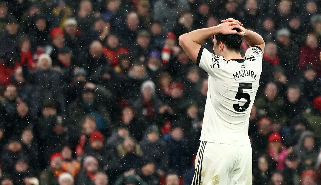 Pemain Manchester United, Harry Maguire memegang kepalanya setelah gagal mencetak gol ke gawang Liverpool pada laga lanjutan Liga Inggris 2024/2025 di Stadion Anfiled, Liverpool, Inggris, Minggu (05/01/2024). (AFP/Darren Staples)