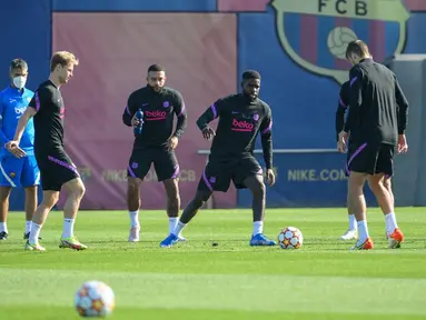 Pemain Barcelona Memphis Depay (kiri) dan Samuel Umtiti (tengah) bersama rekan satu tim mereka saat sesi latihan di Barcelona, Spanyol, Selasa (19/10/2021). Barcelona akan menghadapi Dynamo Kiev pada pertandingan Grup E Liga Champions. (LLUIS GENE/AFP)