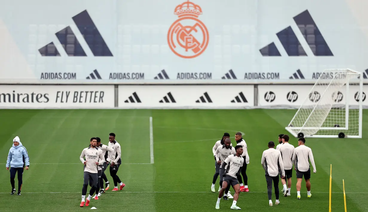 Para pemain Real Madrid melakukan pemanasan saat berlatih menjelang pertandingan babak 16 besar Liga Champions 2024/2025 melawan Atletico Madrid di Real Madrid Sports City, Valdebebas, Spanyol, Senin (03/03/2025) waktu setempat. (AFP/Thomas Coex)