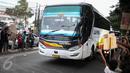 Bus melintas di dekat sejumlah anak yang meminta klakson pesan Om Telolet Om di Jalan Raya Bogor, Jakarta, Sabtu (24/12). Libur sekolah dimanfaatkan anak-anak untuk berburu bus yang membunyikan klakson telolet. (Liputan6.com/Faizal Fanani)