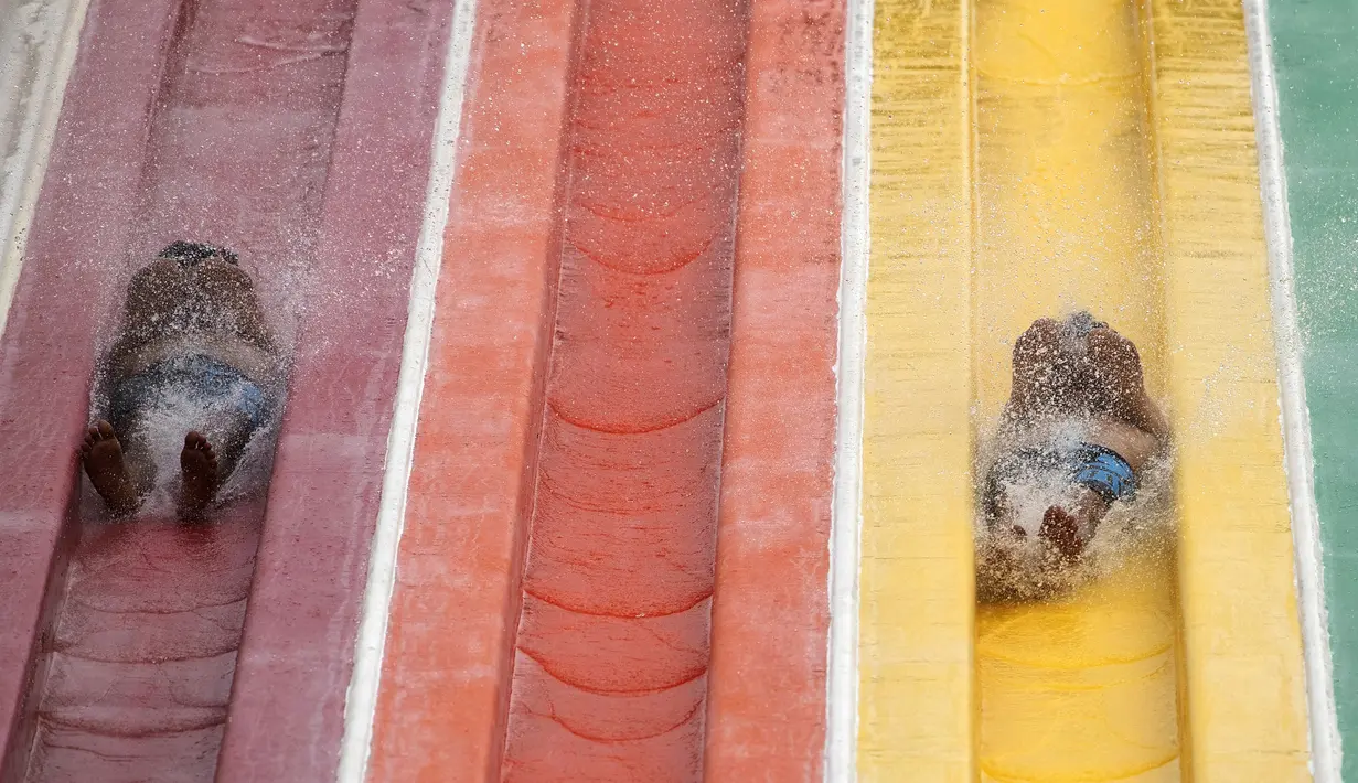 Pengunjung berseluncur saat berenang di Siam Amazing Park, Bangkok, Thailand, Rabu (17/6/2020). Keseharian warga Bangkok berangsur normal setelah pemerintah terus melonggarkan pembatasan terkait pandemi virus corona COVID-19. (AP Photo/Sakchai Lalit)