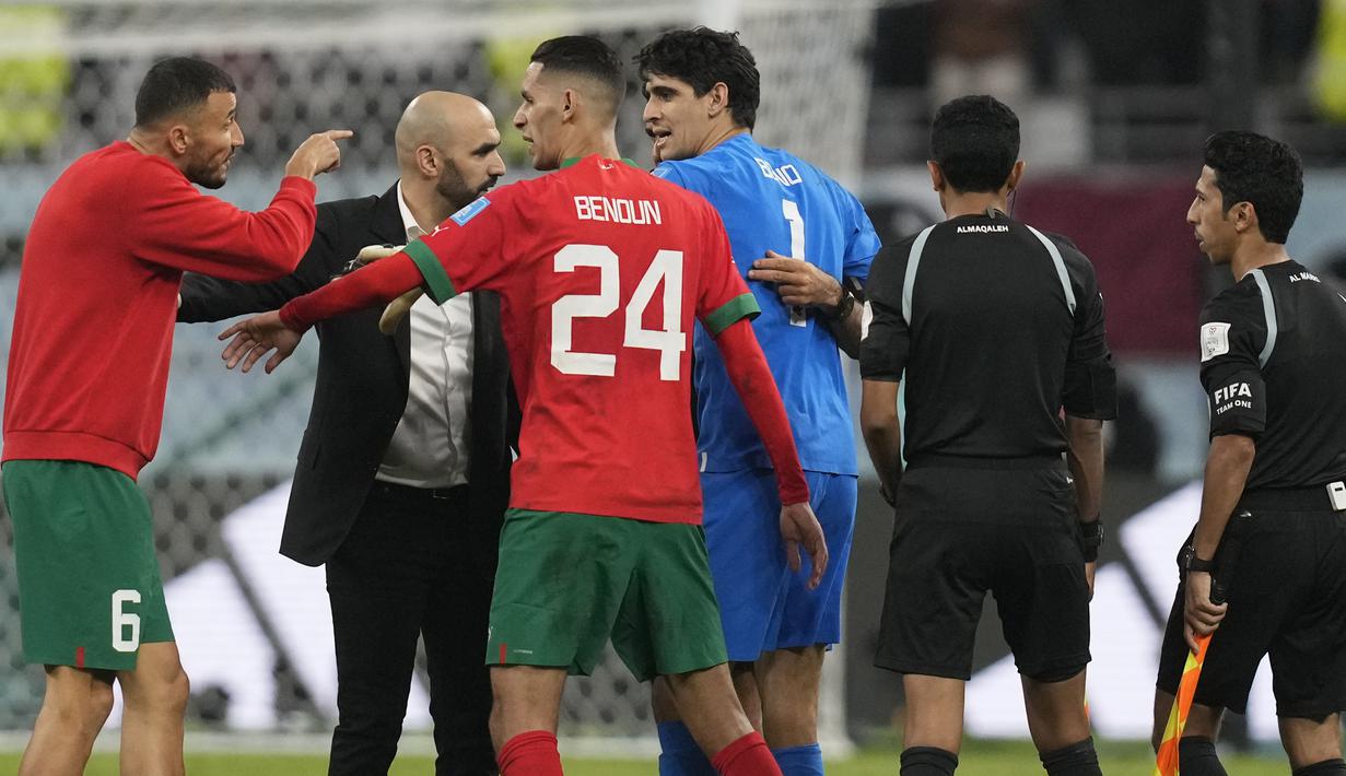 Pelatih Maroko, Walid Regragui (dua kiri) dan kapten tim, Roman Saiss (kiri) juga berkonfrontasi dengan Abdulrahman Al Jassim (dua kanan). Mereka menunjukkan kegeraman terhadap sang pengadil laga. (AP Photo/Thanassis Stavrakis)