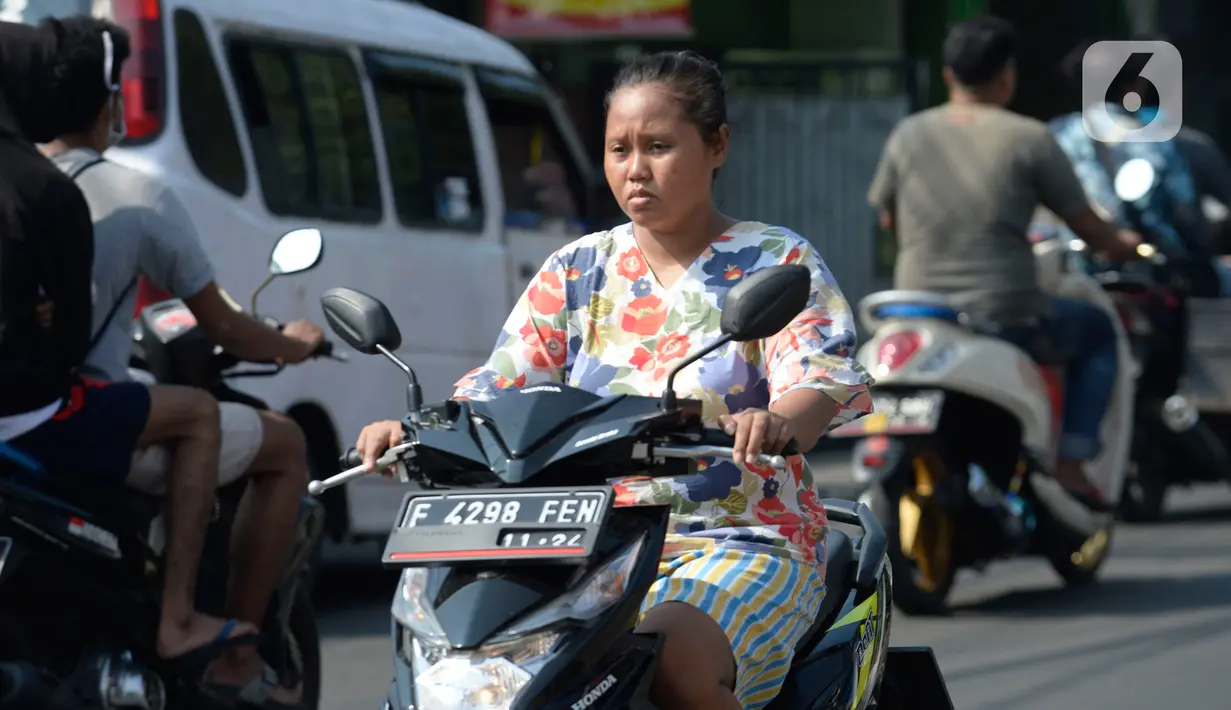 Pengendara motor tidak mengenakan masker melintas di Tangerang Selatan, Banten, Rabu (22/7/2020). Warga masih tidak peduli kesehatan dirinya sendiri dan orang lain, tentang bahayanya penyeberan virus corona (COVID-19) yang terus meningkat di Indonesia. (merdeka.com/Dwi Narwoko)