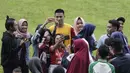 Pemain Arema FC, Hanif Sjahbandi, foto bersama dengan fans usai sesi latihan di Stadion Gajayana, Malang, Kamis (11/4). Setelah sesi latihan, pemain Arema FC melayani permintaan fans untuk foto bersama. (Bola.com/Yoppy Renato)