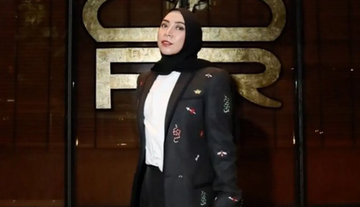 <p>Di saat memakai baju dengan nuansa monokrom, Melly menambahkan detail pada jas yang digunakannya sehingga terlihat lebih edgy. (Foto: Melly Goeslaw/ Instagram)</p>