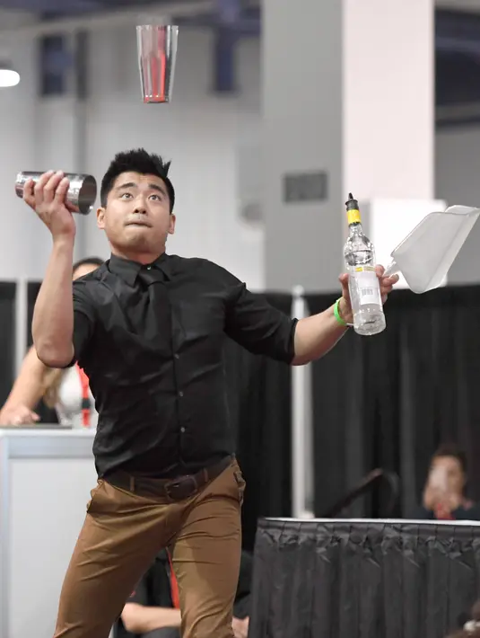 Bartender Ram Ong saat berkompetisi dalam Shake It Up Flair Competition pada hari kedua dari Nightclub & Bar Convention and Trade Show tahunan ke-34 di Las Vegas, Nevada (26/3). (AFP Photo/Ethan Miller)