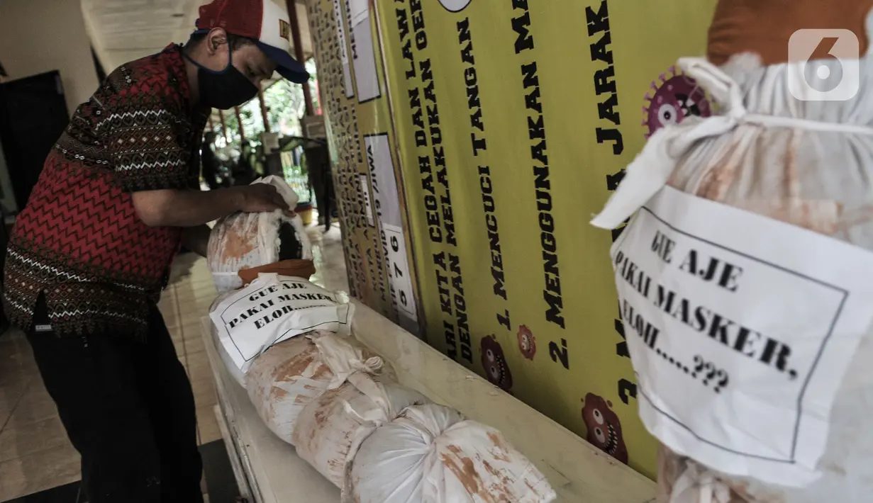 Pekerja memasang boneka pocong dan peti mati di Kantor Kecamatan Senen, Jakarta, Kamis (13/8/2020). Pemkot Jakpus menyiapkan peti mati dan boneka pocong di setiap kecamatan sebagai peringatan akan bahaya Covid-19 dan imbauan untuk tidak mengabaikan protokol kesehatan. (merdeka.com/Iqbal Nugroho)