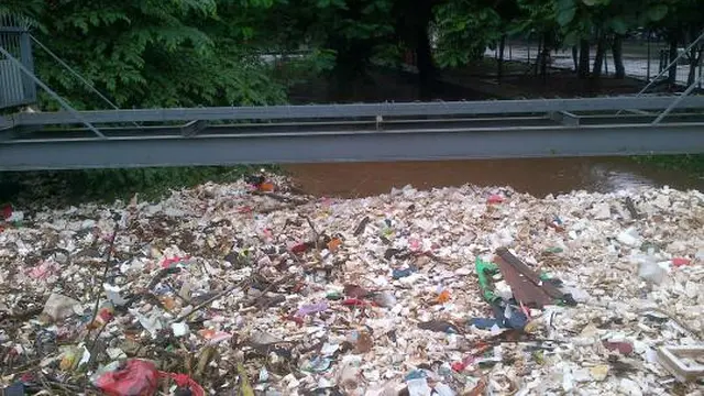 Warga memungut sampah banjir di kali Pasar Induk