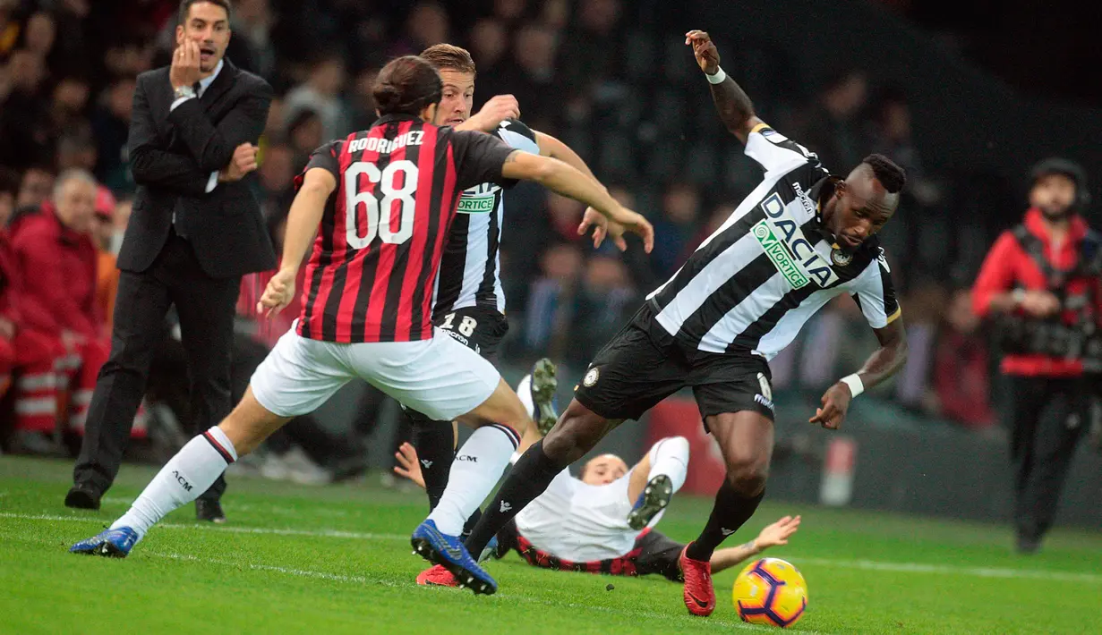 Pemain Udinese, Seko Fofana berusaha melewati bek AC Milan, Ricardo Rodriguez saat bertanding di Liga Italia di stadion Friuli Dacia Arena, Italia (4/11). Milan menang 1-0 berkat gol tunggal Alessio Romagnoli jelang akhir laga. (AP Photo/Sefano Lancia)