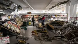 Barang dagangan berserakan dan plafon rusak di sebuah supermarket di Shiroishi, prefektur Miyagi, setelah gempa magnitudo 7,3 mengguncang timur laut Jepang, Kamis (17/3/2022). Gempa pada Rabu malam ini menyebabkan dua orang meninggal dunia serta 94 orang alami luka-luka. (Charly TRIBALLEAU/AFP)