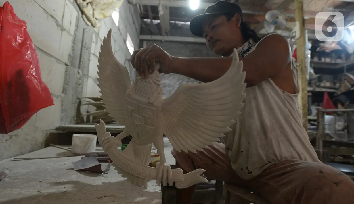 Perajin menyelesaikan kerajinan lambang Garuda Pancasila di bengkel rumahan, Jakarta, (13/8/2020). Menko bidang Perekonomian Airlangga Hartanto memaparkan anggaran Pemulihan Ekonomi Nasional (PEN) dalam bentuk bantuan bagi UMKM tercatat Rp32,5 triliun per 3 Agustus 2020. (merdeka.com/Imam Buhori)