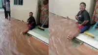 Viral seorang pria jadi tanggul hidup agar air banjir enggak masuk rumah (Sumber: Twitter/KucengTerbanggg)