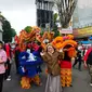 Seorang warga Garut, sengaja berfoto di depan carnaval barongsai dalam puncak perayaan cap go meh di Garut, Jawa Barat (Liputan6.com/Jayadi Supriadin)