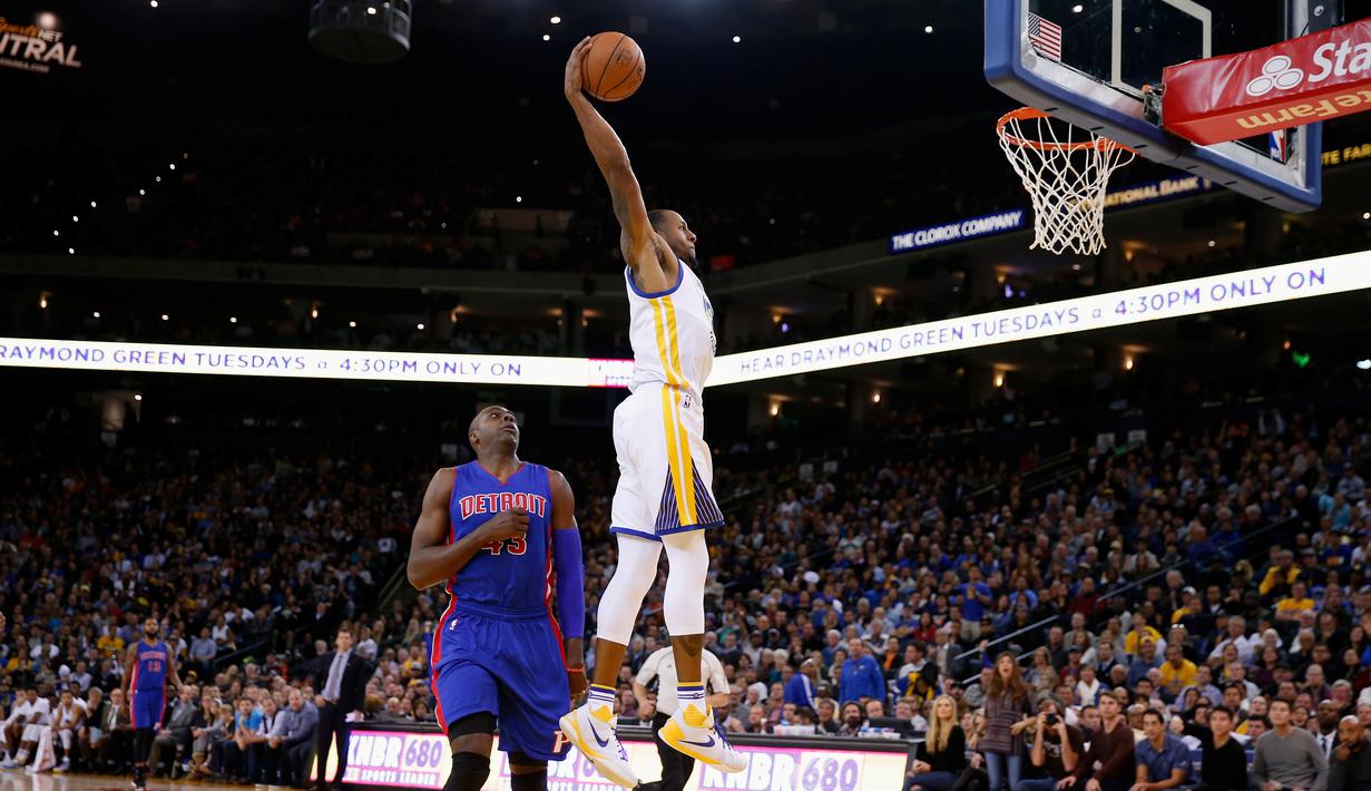 Pebasket Golden State Warriors Andre Iguodala melakukan Dunk saat dibayangi pebasket Detroit Pistons Anthony Tolliver di ORACLE Arena, California, Senin (9/11/2015). Warriors menang 109-95. (Getty Images/AFP/Ezra Shaw)