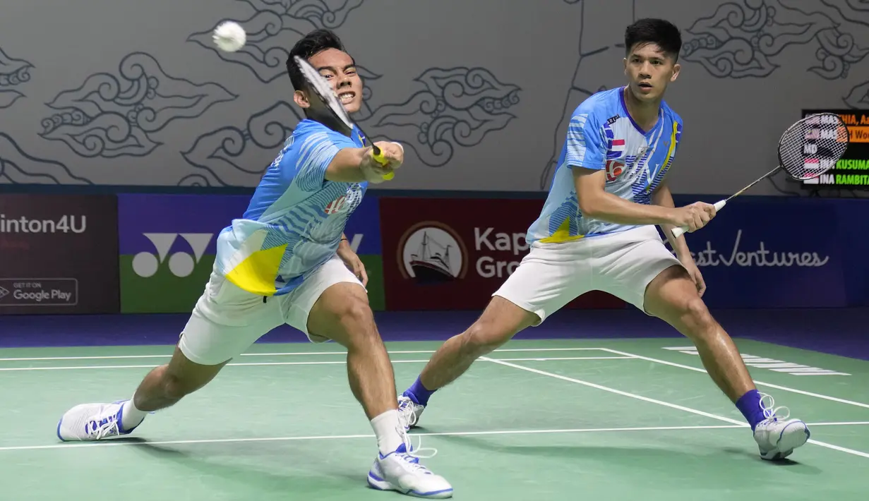 Ganda putra Indonesia Pramudya Kusumawardana (kiri) dan Yeremia Rambitan mengembalikan kok ke arah pasangan Malaysia Aaron Chia/Soh Wooi Yik pada perempat final Indonesia Open 2022 di Istora Senayan, Jakarta, Jumat (17/6/2022). Pram/Yere hanya membutuhkan satu poin untuk masuk semifinal Indonesia Open. Namun, bencana datang dengan cedera Yeremia. (AP Photo/Dita Alangkara)
