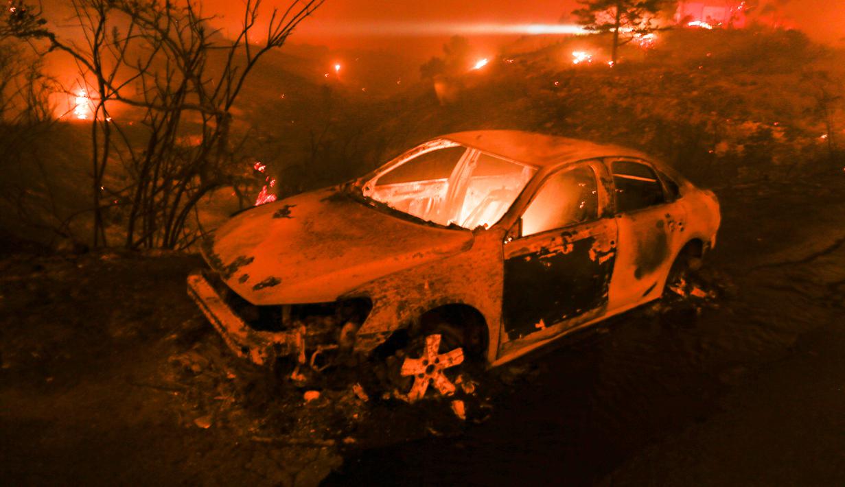 Sebuah kendaraan terbakar saat kebakaran melanda Pacific Coast Highway di Malibu, California, AS, Jumat (9/11). Calabasas dan Malibu merupakan permukiman bagi sejumlah selebriti papan atas AS. (AP Photo/Ringo H.W. Chiu)