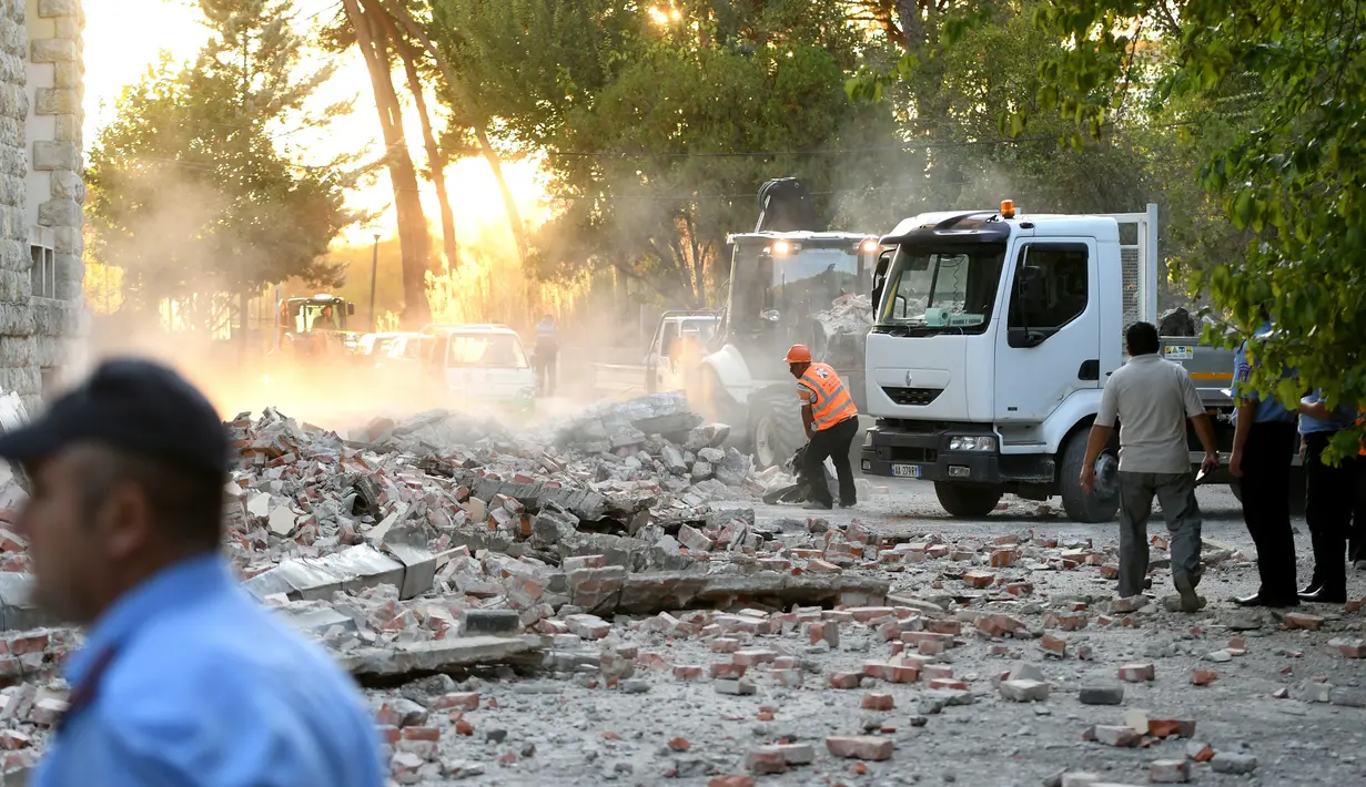 Petugas membersihkan puing-puing atap gedung yang runtuh sai gempa berkekuatan 5,6 magnitudo mengguncang Tirana, Albania (21/9/2019). Menurut lembaga survei Amerika Serikat, titik pusat gempa berada dekat Durres, kurang dari 40 kilometer sebelah barat ibu kota Tirana. (AFP Photo/Gent Shkullaku)