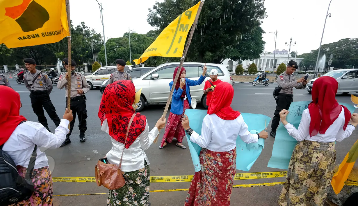 Sejumlah polisi menjaga aksi unjuk rasa puluhan wanita cantik dari Pergerakan Mahasiswa Islam Indonesia Puteri, di depan Istana Merdeka, Jakarta, Senin (1/6/2015). Aksi tersebut untuk memperingati Hari Lahir Pancasila. (Liputan6.com/Faizal Fanani)