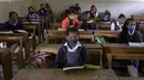 Siswa yang mengenakan masker menghadiri kelas saat sekolah dibuka kembali setelah ditutup selama berbulan-bulan karena pandemi COVID-19 di Ahmedabad, India, Senin (11/1/2021). Negara bagian Gujarat telah membuka kembali sekolah hanya untuk kelas 10 dan 12. (AP Photo/Ajit Solanki)