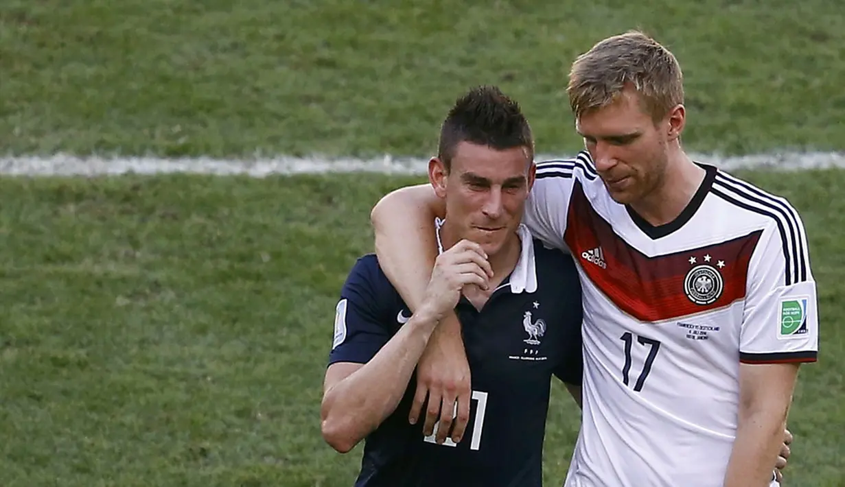 Pemain belakang Timnas Jerman, Per Mertesacker (kanan) merangkul rekan setimnya di klub Inggris, Arsenal, Laurent Koscielny (Perancis) usai berlaga di Stadion Maracana, Rio de Janeiro, (4/7/2014). (REUTERS/Ricardo Moraes)