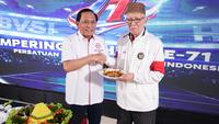Ketua Umum Persatuan Bola Voli Seluruh Indonesia (PBVSI), Imam Sudjarwo (kiri) memberikan potongan tumpeng pertama kepada Purnama S. Yamil pada perayaan hari ulang tahun ke-71 yang dilaksanakan di Gedung Serbaguna Padepokan Voli Sentul, Kamis (26/2/2026) sore WIB. (Bola.com/Abdul Aziz)