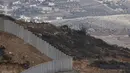 Pembangunan tembok tersebut dianggap sebagai pelanggaran kedaulatan Lebanon serta melanggar Resolusi Dewan Keamanan PBB 1701. Tampak dalam foto yang diambil dari Israel memperlihatkan perbatasan yang memisahkan Israel utara dari Lebanon selatan, dengan desa Lebanon Ain Ebel terlihat di latar belakang pada 16 November 2025. (Jalaa MAREY/AFP)