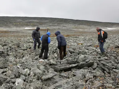 Arkelolog dan dua pemburu yang menemukan sebilah pedang milik bangsa Viking menelusuri sebuah gunung di Norwegia, 4 September 2017. Pedang dari bangsa Viking itu ditemukan pemburu rusa kutub, Einar Ambakk, saat berburu di antara bebatuan. (AP Photo)