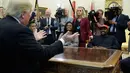 Presiden AS, Donald Trump bertemu dengan rapper Kanye West di Oval Office, Gedung Putih, Kamis (11/10). Pertemuan Kanye West dan Trump menjadi pertemuan kedua pada tahun ini setelah sebelumnya ia diundang Trump pada Mei lalu. (AP/Evan Vucci)