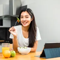 Ilustrasi perempuan makan makanan sehat/copyrightshutterstock/GBJSTOCK