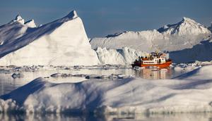 Sebuah perahu yang membawa wisatawan bermanuver di antara gunung es yang mengapung di Disko Bay, Ilulissat, Greenland barat, pada 30 Juni 2022. (Odd ANDERSEN/AFP)