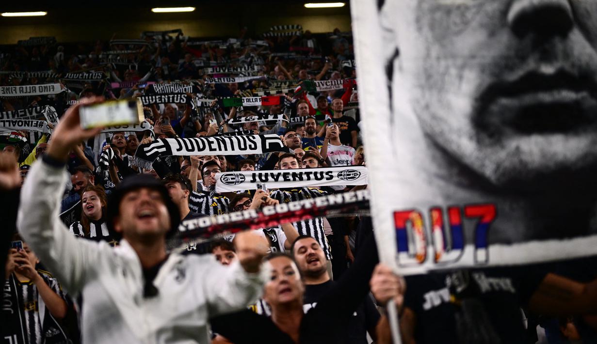 Suporter Juventus membentangkan syal saat mendukung timnya pada laga lanjutan Liga Italia 2023/2024 melawan Lecce di Allianz Stadium, Juventus, Italia, Rabu (27/09/2023). Kemenangan 1-0 tersebut membuat Juventus menempati posisi dua klasemen dengan raihan 13 poin. Sementara itu, Lecce harus turun menjadi posisi keempat dengan koleksi 11 poin. (AFP/Marco Bertorello)
