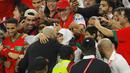 Pelatih Maroko, Walid Regragui, merayakan kemenangan atas Portugal bersama keluarganya pada laga perempat final di Stadion Al-Thumama, Sabtu (10/12/2022). (AFP/Odd Andersen)