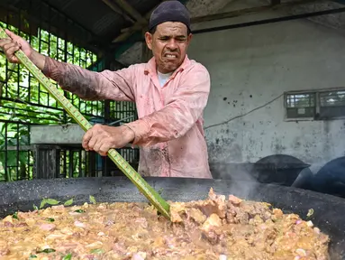 Seorang pria memasak kari tradisional untuk dibagikan saat merayakan Maulid Nabi Muhammad SAW di Krueng Barona Jaya pada 28 September 2023. (Chaideer Mahyuddin/AFP)