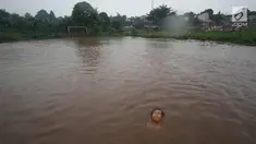 Seorang anak bermain di lapangan yang terendam banjir di kawasan Kemang, Jakarta, Kamis (16/11). Tingginya intensitas hujan dan pesatnya pembangunan menyebabkan kawasan tersebut langganan banjir karena luapan Kali Krukut. (Liputan6.com/Immanuel Antonius)