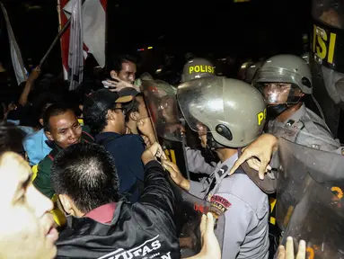 Massa aksi terlibat bentrok dengan polisi yang berjaga saat menggelar aksi unjuk rasa di depan Istana Negara, Kamis (12/1). Dalam aksinya mereka menuntut Presiden Jokowi-JK untuk membuat kebijakan yang pro terhadap rakyat. (Liputan6.com/Faizal Fanani)