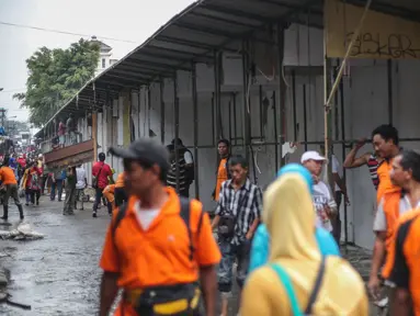 Sebanyak 57 kios pedagang pakaian di sepanjang Jalan Jatibaru X, Tanah Abang, Jakarta dibongkar petugas gabungan Satpol PP Kota dan DKI, Minggu (3/5/2015). Pembongkaran dilakukan karena kios tersebut menutupi saluran air . (Liputan6.com/Faizal Fanani)