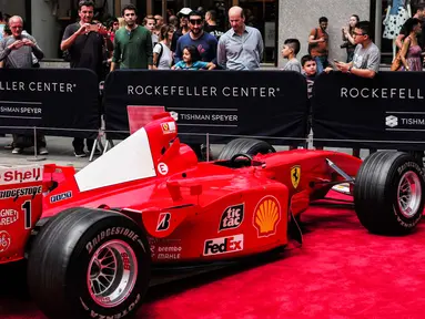 Pengunjung melihat mobil mantan pembalap Ferrari F1 dari Jerman, Michael Schumacher saat dipamerkan di perayaan ulang tahun Ferrari ke-70 di Rockefeller Plaza, New York, AS (8/10). (AFP Photo/Jewel Samad)