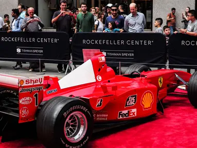Pengunjung melihat mobil mantan pembalap Ferrari F1 dari Jerman, Michael Schumacher saat dipamerkan di perayaan ulang tahun Ferrari ke-70 di Rockefeller Plaza, New York, AS (8/10). (AFP Photo/Jewel Samad)